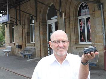 Herbert Haar ist leidenschaftlicher Modelleisenbahner. Das Bild zeigt ihn vor dem Bahnhof in Bad Staffelstein mit einer E-Lok aus den 1940er Jahren. Foto:  Popp