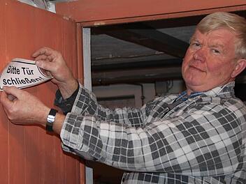 Bitte an die Hausbewohner: Regiearbeiter Alexander Miller platziert einen Aufkleber an der Kellertüre. Foto: Ulrike Müller