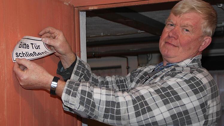 Bitte an die Hausbewohner: Regiearbeiter Alexander Miller platziert einen Aufkleber an der Kellertüre. Foto: Ulrike Müller