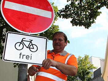Winfried Oberender vom CEB montierte am Dienstag die neuen Hinweisschilder in der Webergasse in Coburg.
