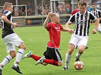 Der zweifache Torschütze der SpVgg Lauter, Jonas Cron (Mitte), wird hier durch ein Foul des Pettstadters Jens Gütlein (links) gestoppt. Foto: Günther Geiling
