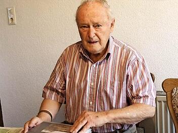 Otto Heinlein blättert in einem der Bilderordner mit vielen Fotos der Grenze bei Heinersdorf.  Foto: Friedwald Schedel