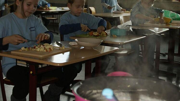Dampfend köchelte der Hirsebrei im Topf, während die Kinder im Koch-Workshop Obst als Einlage schnippelten.