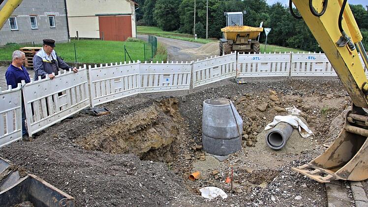 In der Ortsmitte von Kurzewind, hier mit Blick in Richtung Gereuth, schauen Hans Gegner und Georg Baiersdorfer (von links) in eine Baugrube für die neue Abwasseranlage mitten in der Straße.  Foto: Helmut Will
