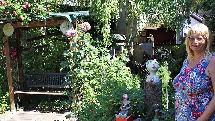 Gartenbesitzerin Elisabeth Hirschmann und ihr "Feierabendbänkchen". Dort hat sie nach getaner Arbeit oft die letzten Sonnenstrahlen genossen.   Foto: Evi Seeger