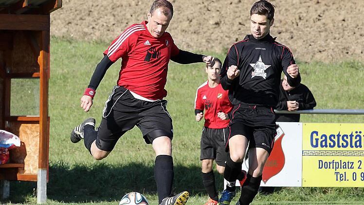 SC-Spielertrainer Wolfgang Walde schlägt einen Pass; rechts Jonas Lunz vom ASV Stübig
