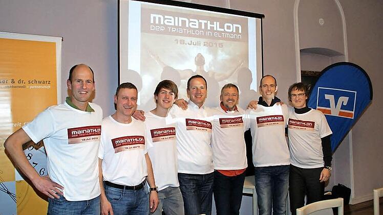 Die Köpfe des Mainathlon (von links): Matthias Pfuhlmann, Joachim Stark, Felix Pfuhlmann, Schirmherr Bürgermeister Michael Ziegler, Ralf Steinhäuser, Uli Pfuhlmann und Jens Witthüser vor der "Symbolfigur", Bodybuilder Stefan Häußler aus Bamberg.  Foto: Sabine Weinbeer