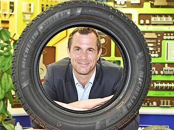 Der Hallstadter Werkdirektor Jens Schlemmer blickt durch einen Michelin Alpin 6. Das Modell ist so neu wie der Chef: Seit April läuft in Hallstadt die Serienfertigung des Winterreifens, der in diesen Tagen am Markt eingeführt wird. Schlemmer führt seit 1. April das Werk.  Foto: Ronald Rinklef