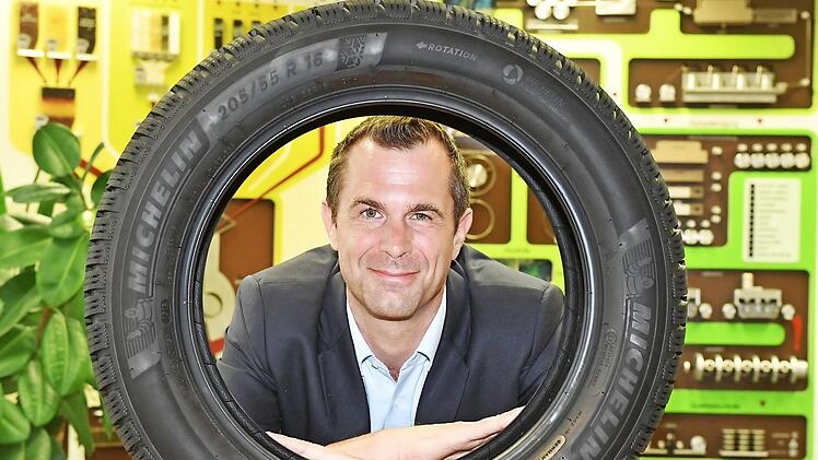 Der Hallstadter Werkdirektor Jens Schlemmer blickt durch einen Michelin Alpin 6. Das Modell ist so neu wie der Chef: Seit April läuft in Hallstadt die Serienfertigung des Winterreifens, der in diesen Tagen am Markt eingeführt wird. Schlemmer führt seit 1. April das Werk.  Foto: Ronald Rinklef