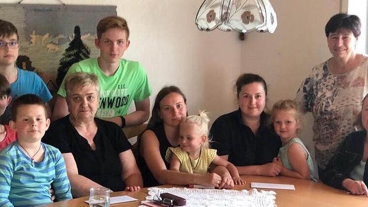Zwei ukrainische Familien, die in Ramsthal eine Wohnung gefunden haben, freuen sich über die Spende aus dem von Helene Greubel (hinten rechs) organisierten Kuchenverkauf.