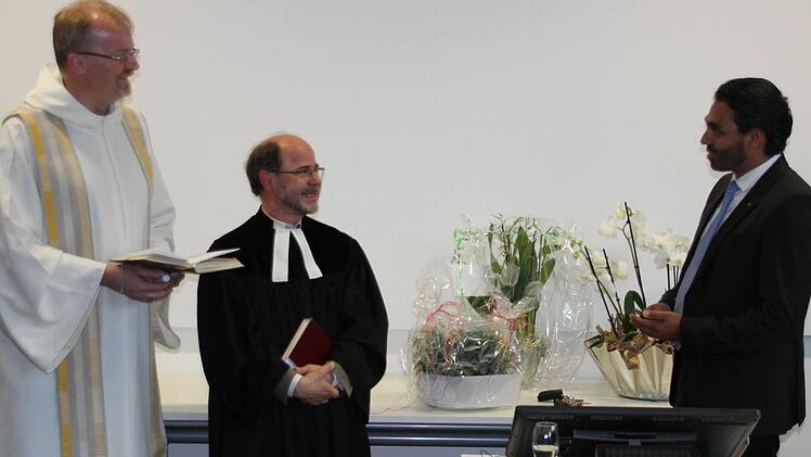 Die beiden Pfarrer Thomas Teuchgräber und Andreas Heindl (von links) segneten das F&E Center. Regionaldekan Thomas Teuchgräber überreichte an Parag Shah, Vorsitzenden der Geschäftsführung, ein Kreuz.  Foto: Friedwald Schedel