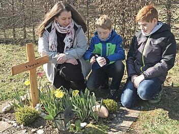 Anja Lemberger mit ihren Kindern am Erdurnengrab ihrer m Oktober 2018 in der 20. Schwangerschaftswoche still geborenen Tochter Vera  Foto: epd