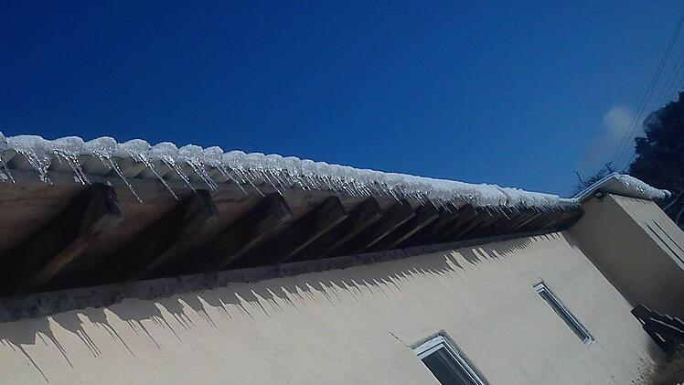 Die Eiszapfen werfen ihre Schatten auf die Hauswand. Foto: Frank Hofmann