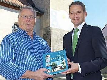 Bürgermeister Johannes Maciejonczyk (r.) überreicht Erich Altheim das erste druckfrische Buchexemplar. Foto: Elke Pieger