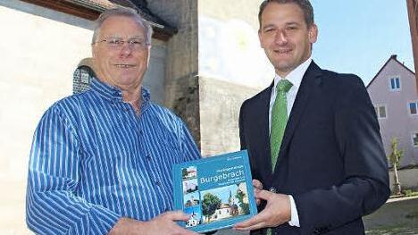 Bürgermeister Johannes Maciejonczyk (r.) überreicht Erich Altheim das erste druckfrische Buchexemplar. Foto: Elke Pieger
