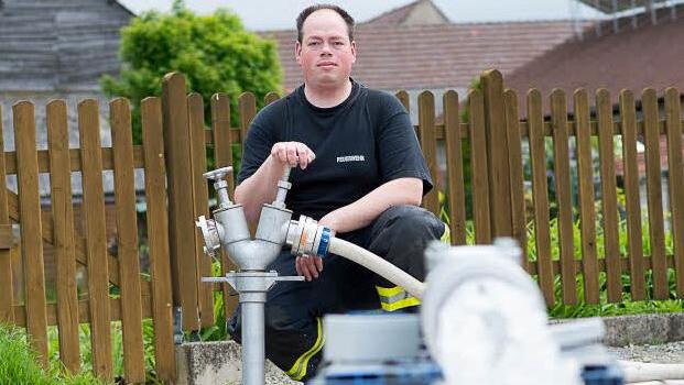 Feuerwehrmann Alexander Marx lässt Wasser durch die neu entwickelte Armatur laufen. Foto: Tobias Köpplinger