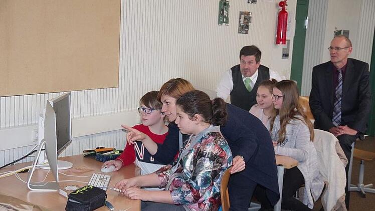 Die Projektmitarbeiterin Claudia Maier (vorne Mitte) gibt kleine Tipps. (Hinten von links) Christian Pfadenhauer und Direktor Harald Weichert sind begeistert, wie schnell die F&uuml;nftkl&auml;ssler das Prinzip des Calliope Miniverstanden haben. Heike Sch&uuml;lein