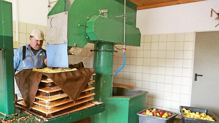 Ingo Janson vom Obst- und Gartenbauverein Marktgraitz bedient die Saftpresse im "Graatzer" Kelterhaus.  Foto: Umweltstation Landkreis Lichtenfels/Michael Stromer