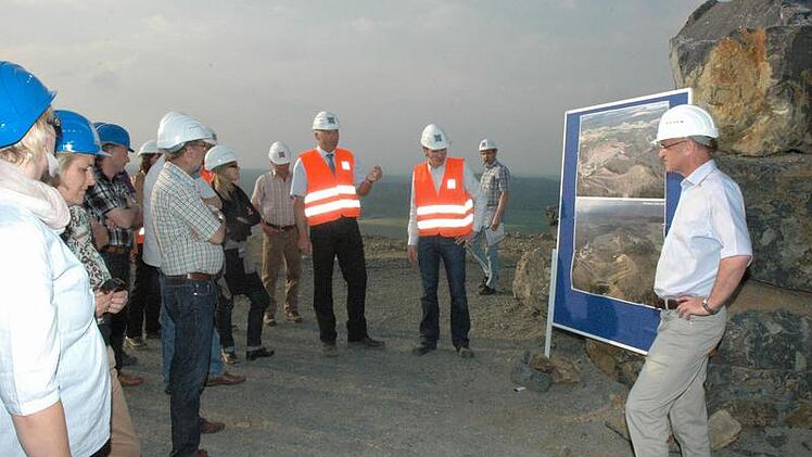 Interessiert lauschen die Ratsmitglider den Ausführungen der Männer von der "Basalt-Actiengesellschaft"  auf dem höchsten Punkt des Zeilbergs. Rechts Bürgermeister Wilhelm Schneider und in den Warnwesten von links Torsten Honkisch und Christian Papelitzky. Foto: Gerhard Schmidt