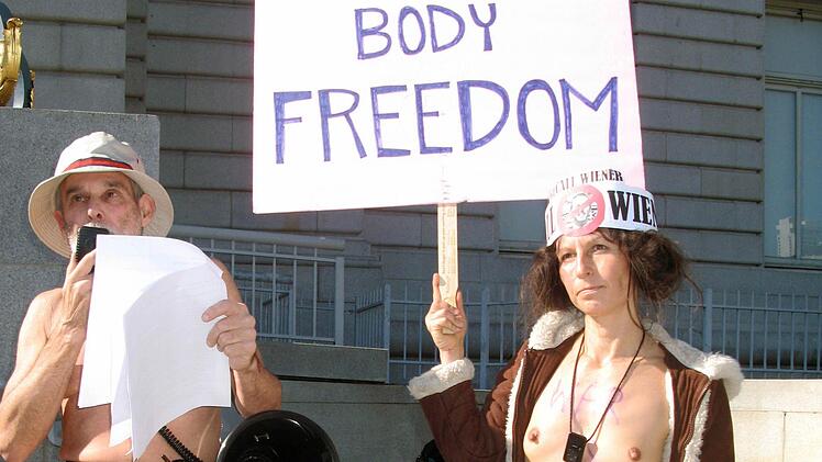Die 43-j&auml;hrigen nackten Demonstranten Gypsy Taub und George Davis (links) halten in San Francisco (USA) vor dem Rathaus der Stadt ein Plakat mit der Aufschrift ,Body Freedom'. Eine Handvoll Nudisten war am Freitag bei Protesten gegen ein neues Nacktheitsverbot im kalifornischen San Francisco festgenommen worden. Der Stadtrat hatte im November 2012 ein Gesetz verabschiedet, nach dem entbl&ouml;&szlig;te Genitalien auf Stra&szlig;en, Pl&auml;tzen und in &ouml;ffentlichen Verkehrsmitteln verboten sind. Foto: dpa