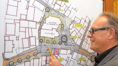 Der frühere Stadtplaner Wolfgang Russ mit einem Plan der Ortsmitte von Arnshausen. Foto: Peter Rauch/Archiv