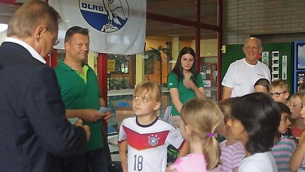 Auch Emelie ist eine "sichere Schwimmerin" und erhielt von B&uuml;rgermeister Wolfgang Beiergr&ouml;&szlig;lein (links) ihr Abzeichen. Foto: Heike Sch&uuml;lein