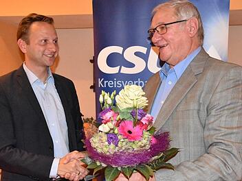 CSU-Gemeinderatsmitglied Siegried Escher (rechts) gratulierte Bürgermeister Robert Bosch zur Nominierung und hatte für dessen Ehefrau Lisa Blumen dabei. Foto: Uschi Prawitz