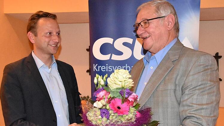 CSU-Gemeinderatsmitglied Siegried Escher (rechts) gratulierte Bürgermeister Robert Bosch zur Nominierung und hatte für dessen Ehefrau Lisa Blumen dabei. Foto: Uschi Prawitz