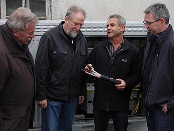 Hans Nagel (2. v. r.) erläutert mit einem Muster den Aufbau der Kabelverlegung, Hans Schütz, Hans Weisel (v. l.) , und Bernd Drummer (r.) hören zu. Foto: Franz Galster