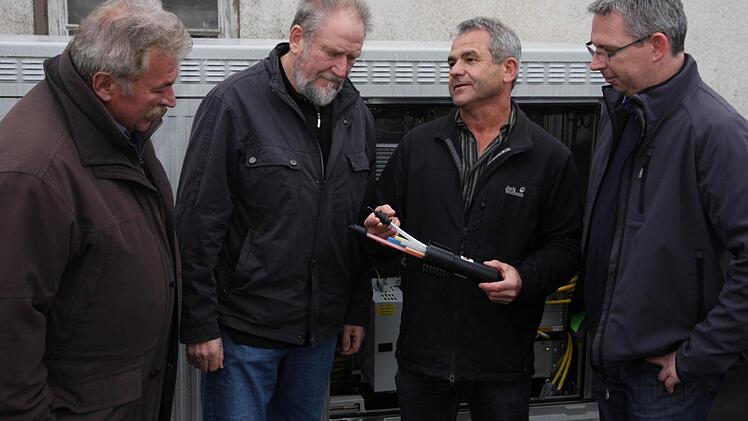 Hans Nagel (2. v. r.) erläutert mit einem Muster den Aufbau der Kabelverlegung, Hans Schütz, Hans Weisel (v. l.) , und Bernd Drummer (r.) hören zu. Foto: Franz Galster