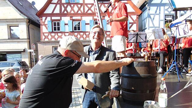 Bürgermeister Heinz Richter schwingt den Holzhammer zum Bieranstich - ein Helfer hält das Fass. Fotos:  Petra Malbrich
