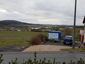 Links liegt der Firmenkomplex Uniwell, rechts die Gebäude der Metzgerei Fuchs, dazwischen (etwa hinter dem blauen Protestanhänger) liegt ein schmaler grüner Streifen. Hier wird das Hochregallager mit 21 Metern Höhe gebaut. Ein Tag der Enttäuschung für die Bürgerinitiative Eyrichshof, deren Mitglieder sich aber geschworen haben, ein waches Auge auf die Entwicklung von Uniwell und das Hochregallager zu haben. Eines Tages, so sind sie sich sicher, könnte es heißen: "Wir haben es doch gesagt..." ...