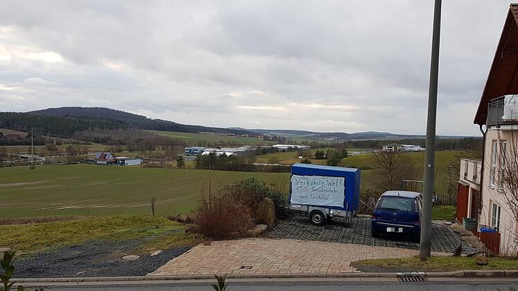Links liegt der Firmenkomplex Uniwell, rechts die Gebäude der Metzgerei Fuchs, dazwischen (etwa hinter dem blauen Protestanhänger) liegt ein schmaler grüner Streifen. Hier wird das Hochregallager mit 21 Metern Höhe gebaut. Ein Tag der Enttäuschung für die Bürgerinitiative Eyrichshof, deren Mitglieder sich aber geschworen haben, ein waches Auge auf die Entwicklung von Uniwell und das Hochregallager zu haben. Eines Tages, so sind sie sich sicher, könnte es heißen: "Wir haben es doch gesagt..." ...
