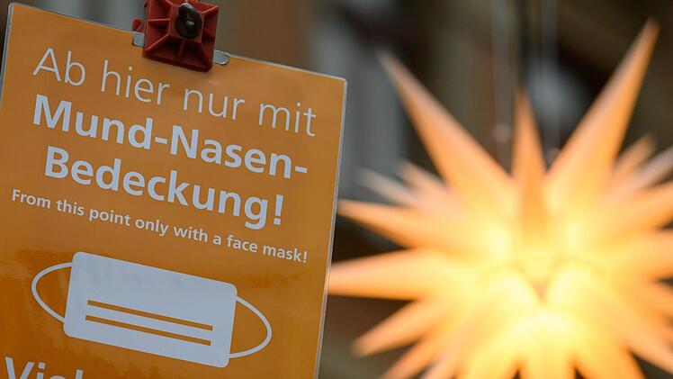 Masken und Abstandsregeln bleiben die erste Wahl. Zusätzlich wird das öffentliche Leben weiter eingeschränkt. Foto: Robert Michael, dpa