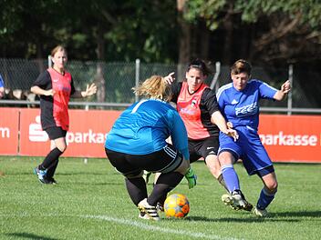 Selina Pelch (rotes Trikot) wird von der Weisendorferin Sarah Weber gestört, Burks Torhüterin Jennifer Späth packet dennoch sicher zu. Foto: Christian Wagner