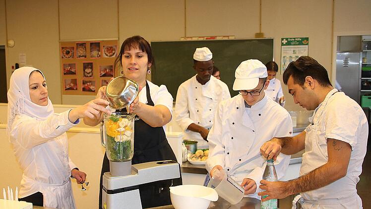 Ingwer, Bananen, Orangen, Grünkohl werden zusammen mit Mineralwasser im  Mixer zerkleinert - fertig ist der Smoothie. Lehrerin Katharina Zeller  füllt gerade den Mixer. Schülerin Rim aus Syrien (links) hilft ihr.Dieter Britz