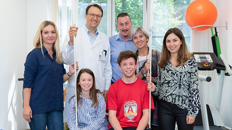 Yunus und Lea mit ihren Familien und Professor Doktor Markus Metzler in den Räumen der Erlanger Uni-Klinik. Foto: Michael Rabenstein/Uni-Klinikum Erlangen
