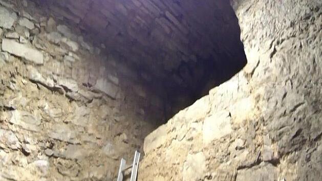 Vom Boden des vom Schutt befreiten Lochgef&auml;ngnisses sieht man oben das kreisrunde "Angstloch" als Zugang. Foto: Jochen Scherbaum
