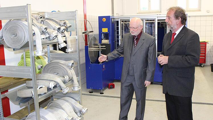 Bürgermeister Rast (l.) führte Landrat Glauber auch die neue Schlauchpflegeanlage vor Augen.