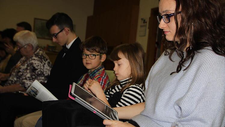 Leder-Einband und Goldschnitt war gestern, heute wird die Bibel auf dem Tablet gelesen: Bettina Radtke wuchs selbst in einer Familie auf, die sich den Zeugen Jehovas zugehörig fühlt. Nun möchte sie, dass auch ihre Kinder Emilia und Aron (daneben) vom Glauben profitieren. Foto: Ulrike Müller