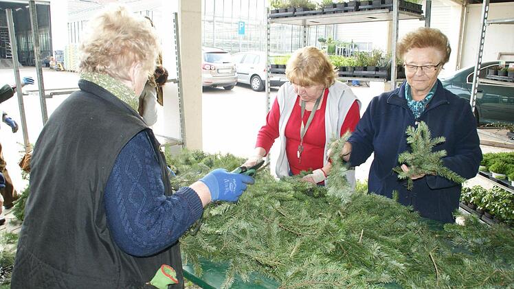 Helma Kraus, Selma Heil und Gabriele Krönert suchen aus den Zweigen Bündelchen zusammen, die dann zu Girlanden gebunden werden. Foto: Sabine Weinbeer
