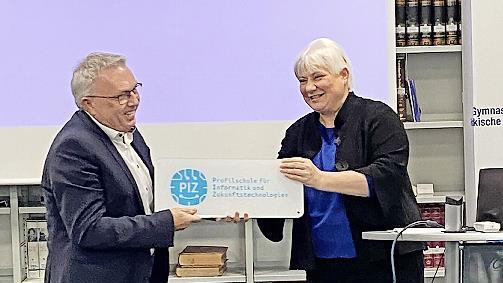 Martina Schmidt-Kessel, die Stellvertreterin des Ministerialbeauftragten für Oberfranken, bei der Übergabe des PIZ-Schildes an Schulleiter Siegfried Reck.