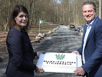 Eine Baumwipfelpfad-Torte zum Geburtstag präsentieren Leiterin Miriam Langenbucher und Staatsforsten-Vorstand Martin Neumeyer. Foto: Herbst