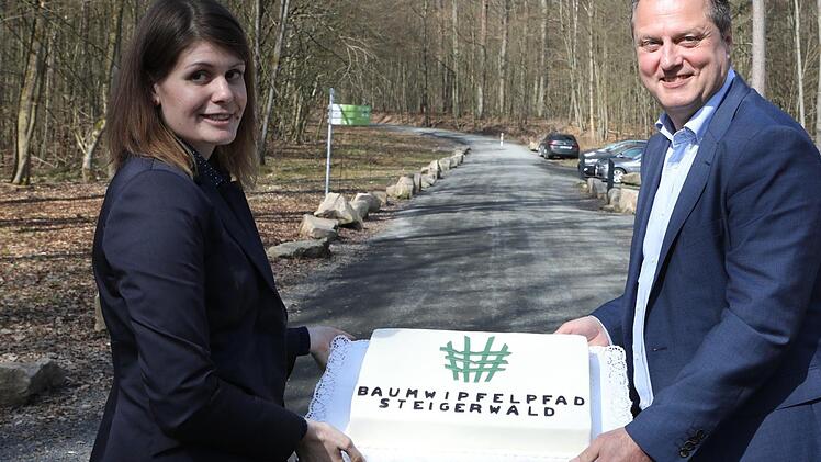 Eine Baumwipfelpfad-Torte zum Geburtstag präsentieren Leiterin Miriam Langenbucher und Staatsforsten-Vorstand Martin Neumeyer. Foto: Herbst