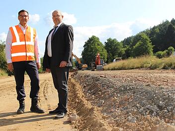 Rüdiger Köhler (links) und Michael Fuchs begutachten die Baustelle. Links entsteht bereits die neue Straße, während rechts die alte zurückgebaut wird. Foto: Julia Raab