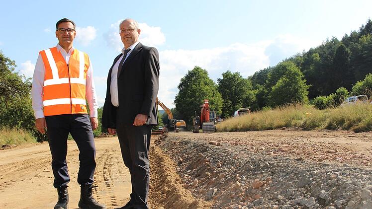 Rüdiger Köhler (links) und Michael Fuchs begutachten die Baustelle. Links entsteht bereits die neue Straße, während rechts die alte zurückgebaut wird. Foto: Julia Raab