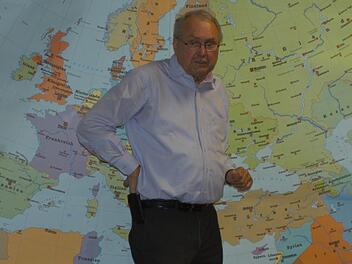 Eduard Lintner vor einer Weltkarte, rechts unten liegt Aserbaidschan Karin Nerche-Wolf