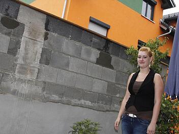 Jennifer Frohberg, die  Tochter der Mieterin in der Hainbrunnenstraße 5, zeigt auf ihrer kleinen Terrasse die Höhe der Mauer. Die Schallschutzwand wurde   im Abstand von  nur  dreieinhalb Metern    vor dem Wohnzimmer errichtet. Foto: Andreas Oswald