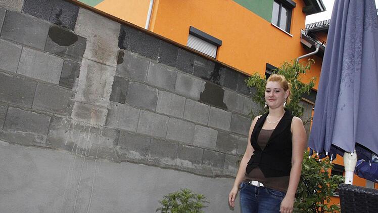 Jennifer Frohberg, die  Tochter der Mieterin in der Hainbrunnenstraße 5, zeigt auf ihrer kleinen Terrasse die Höhe der Mauer. Die Schallschutzwand wurde   im Abstand von  nur  dreieinhalb Metern    vor dem Wohnzimmer errichtet. Foto: Andreas Oswald