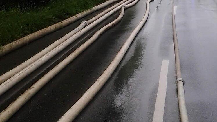 Feuerwehren und Technisches Hilfswerk pumpen am Freitag auf der Erlanger Straße in Neunkirchen am Brand Wasser aus dem Zentrum (Bild links). Die THWler bei der Einsatzbesprechung (oben rechts) und bei der Ausbildung (unten rechts) - hier wird ein Gerüst aufgebaut. Foto: Frank Hofmann